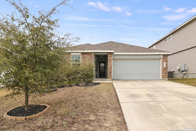 view of front facade featuring concrete driveway, a garage, brick siding, and central AC