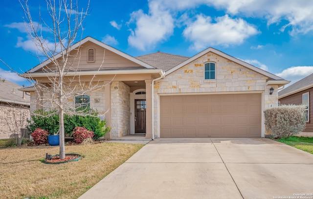 view of front of property featuring stone siding, a front lawn, an attached garage, and driveway