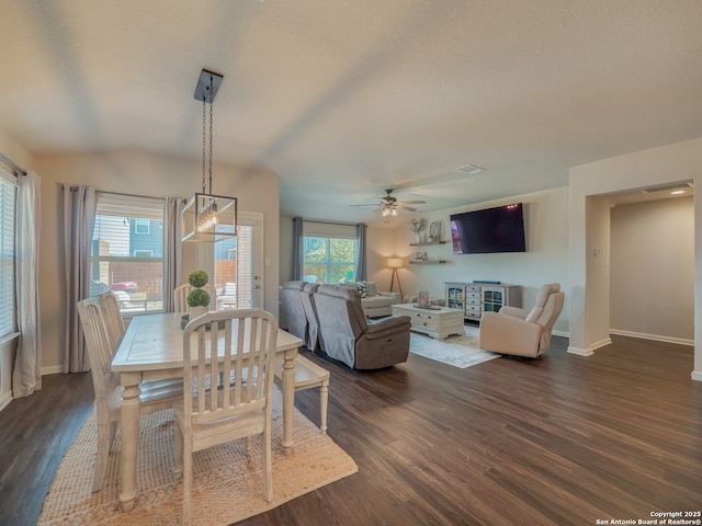 dining space with dark wood finished floors, a healthy amount of sunlight, baseboards, and a ceiling fan