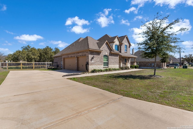 view of front of house featuring a front lawn, driveway, stone siding, fence, and a garage