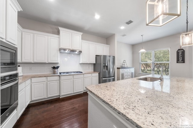 kitchen featuring visible vents, under cabinet range hood, stainless steel appliances, white cabinetry, and a sink