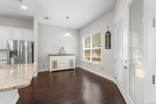 kitchen featuring visible vents, baseboards, stainless steel refrigerator with ice dispenser, dark wood-style floors, and white cabinets