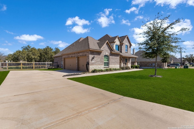 french provincial home with driveway, stone siding, fence, a front yard, and a garage