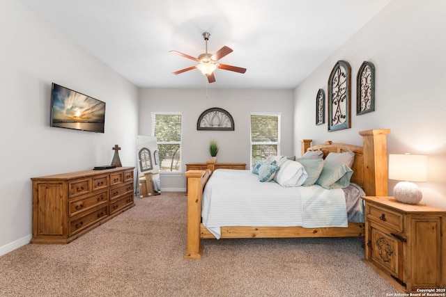 bedroom with light carpet, ceiling fan, and baseboards