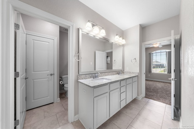 bathroom featuring tile patterned flooring, toilet, and a sink