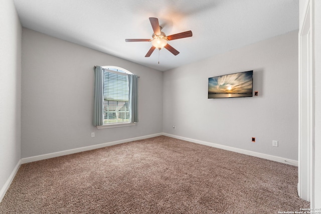 carpeted spare room with baseboards and a ceiling fan