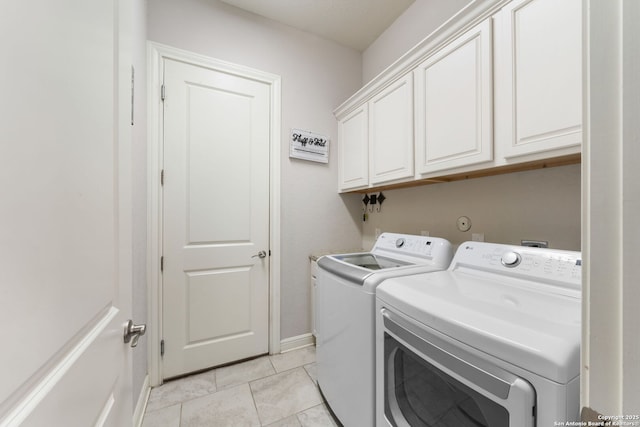 washroom featuring light tile patterned floors, baseboards, cabinet space, and washing machine and dryer