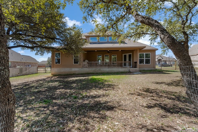 rear view of house with a ceiling fan and fence