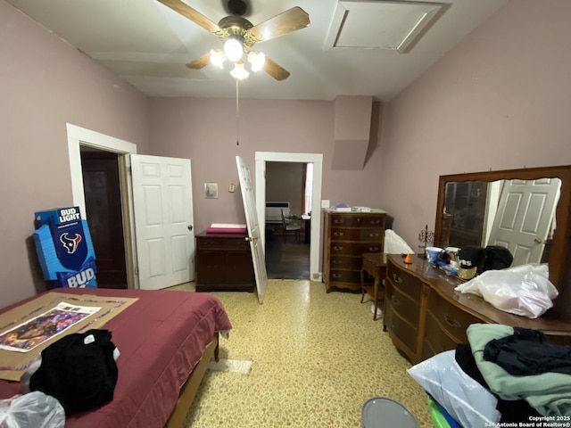 bedroom featuring a ceiling fan, attic access, and light floors