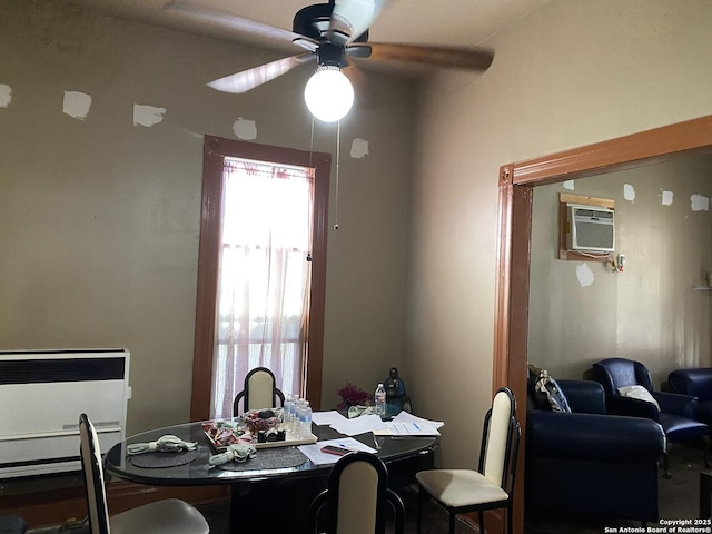 dining area featuring a wall mounted air conditioner, heating unit, and a ceiling fan