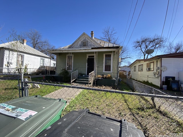 shotgun-style home featuring a porch, fence private yard, and a front lawn