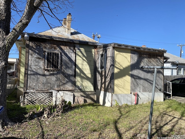 view of side of home with crawl space, a chimney, and fence