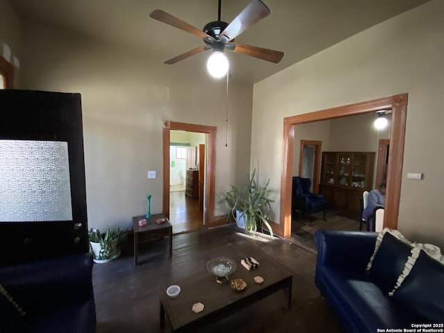 living area with a towering ceiling and ceiling fan