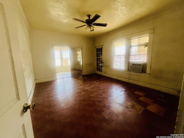 empty room featuring a textured ceiling, crown molding, and ceiling fan