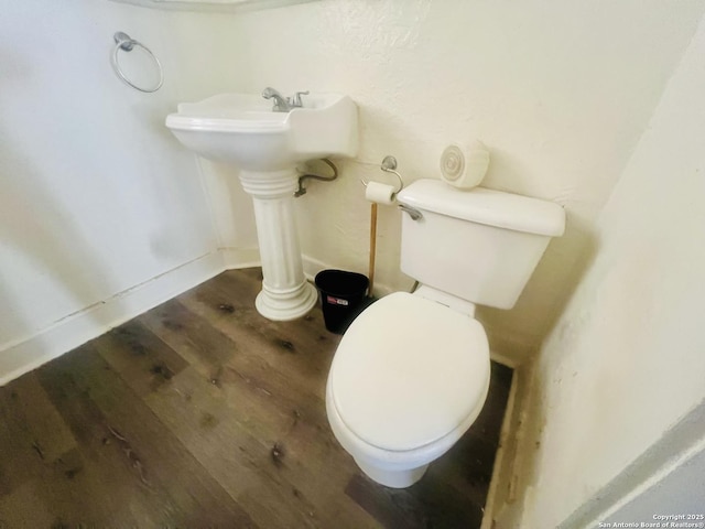 bathroom with toilet and wood finished floors