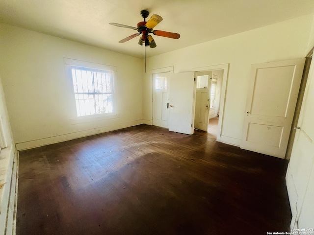 unfurnished bedroom with dark wood-style floors, ceiling fan, and baseboards