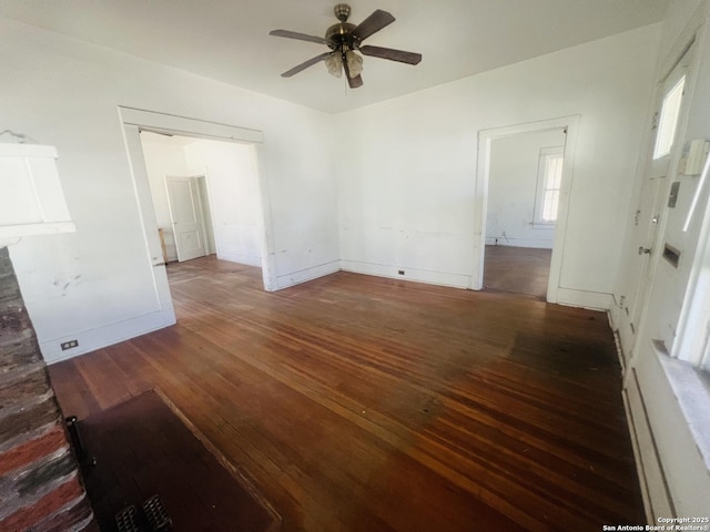 empty room featuring baseboards, wood-type flooring, and ceiling fan