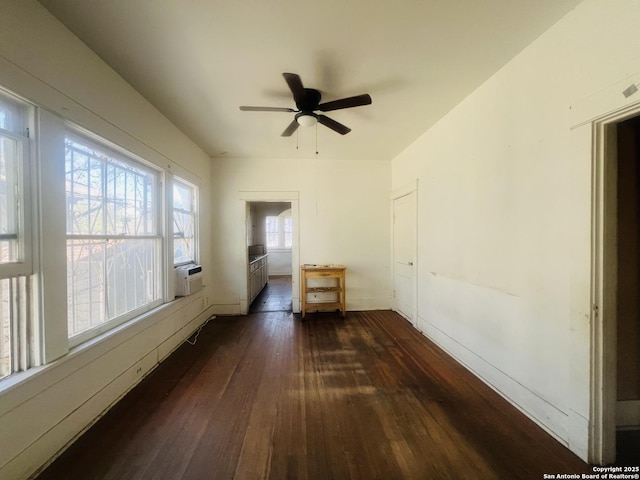 empty room with cooling unit, baseboards, dark wood-style flooring, and ceiling fan