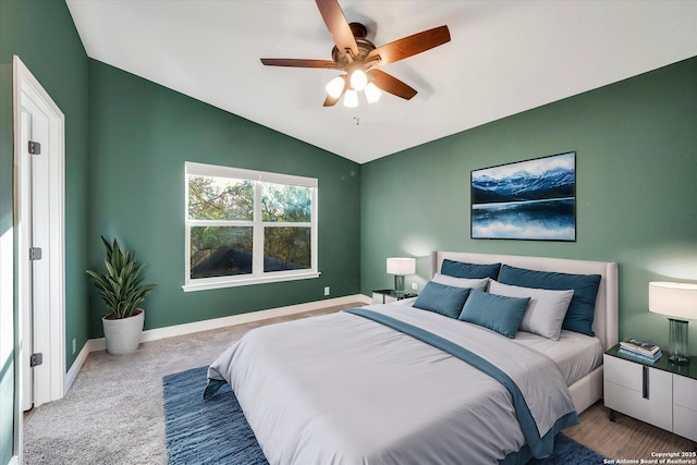 carpeted bedroom with baseboards, lofted ceiling, and a ceiling fan