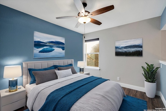 bedroom with a ceiling fan, wood finished floors, and baseboards