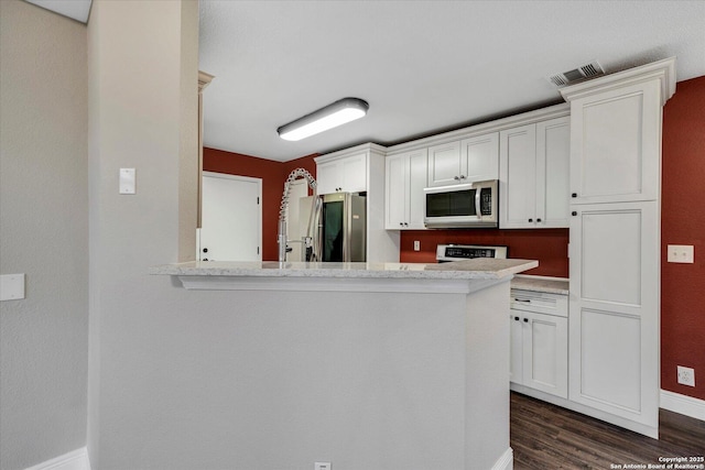 kitchen with baseboards, visible vents, dark wood-style flooring, stainless steel appliances, and white cabinets