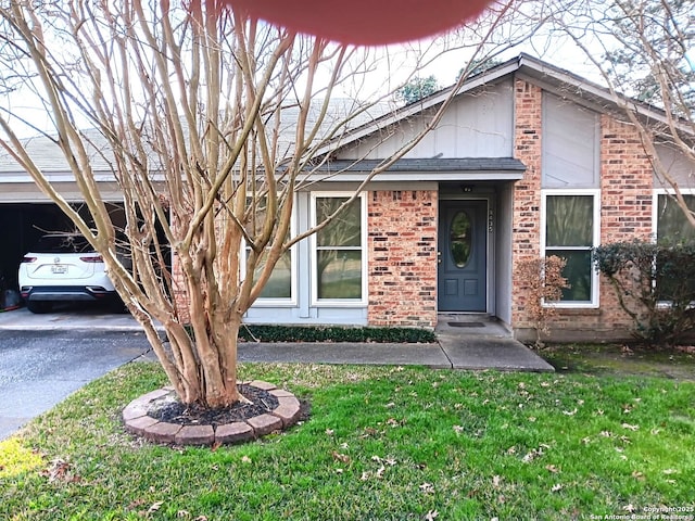 view of front of house featuring a front lawn, brick siding, and roof with shingles