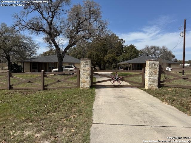 view of gate with a yard and a fenced front yard