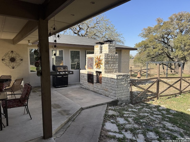 view of patio / terrace with a gate, grilling area, and fence