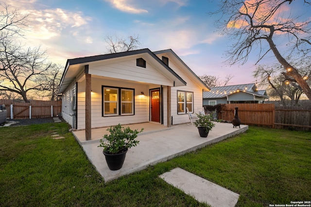 back of property featuring a patio area, a lawn, and a fenced backyard