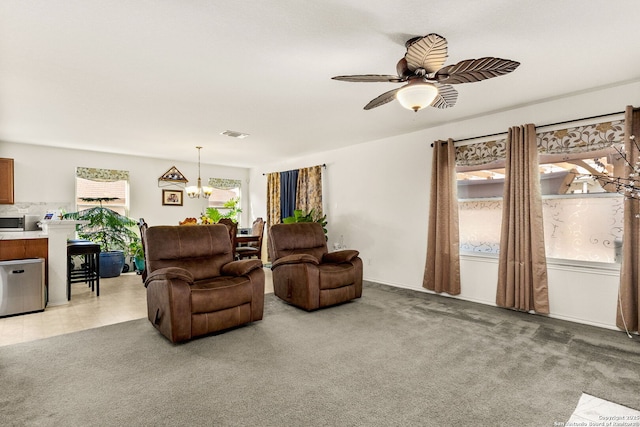 living room with visible vents, light colored carpet, and ceiling fan with notable chandelier