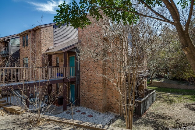 view of property exterior with stairway and brick siding