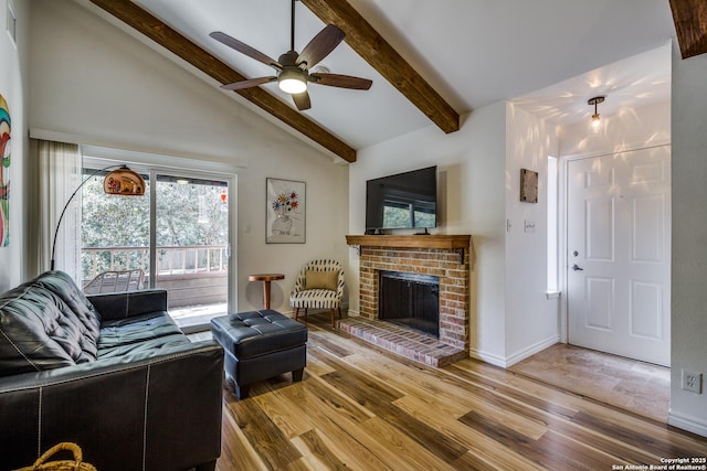 living area with beamed ceiling, wood finished floors, a fireplace, baseboards, and ceiling fan