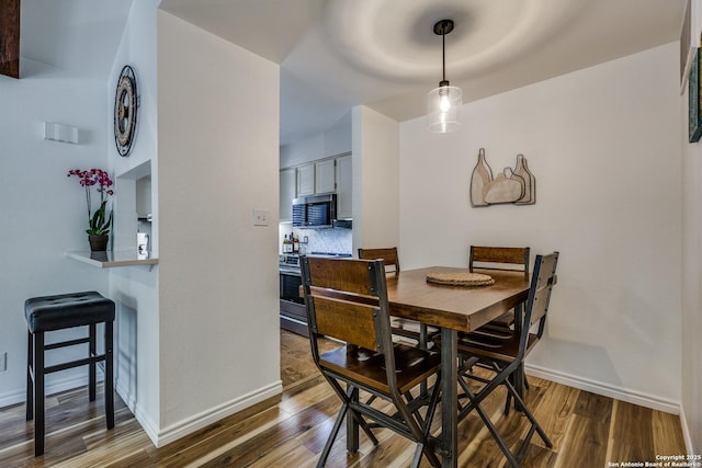 dining area with dark wood finished floors and baseboards