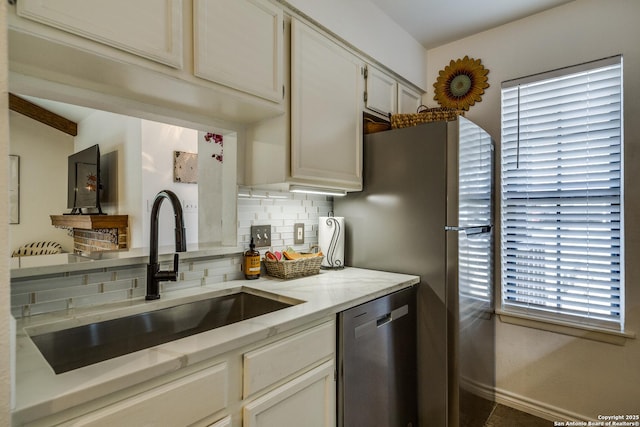 kitchen with decorative backsplash, light stone countertops, appliances with stainless steel finishes, and a sink