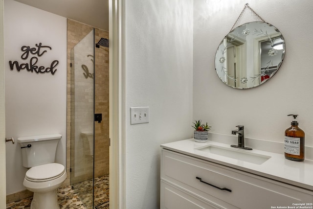 full bathroom featuring vanity, toilet, and a tile shower