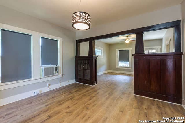 interior space with a ceiling fan, baseboards, and wood finished floors