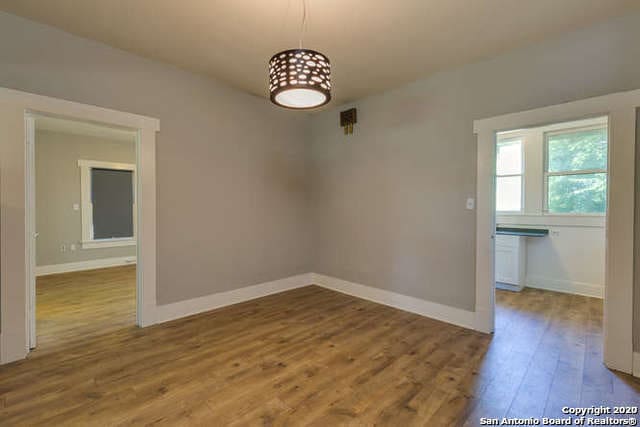 unfurnished dining area featuring wood finished floors and baseboards