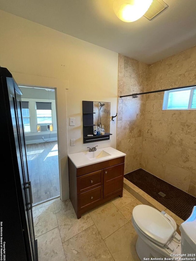 bathroom with vanity, a shower stall, toilet, and visible vents