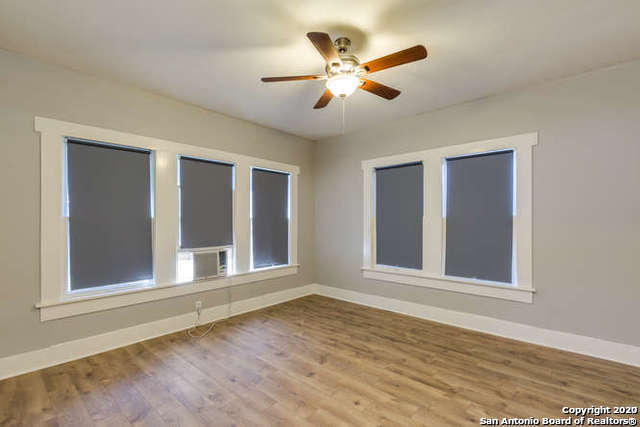 empty room with ceiling fan, baseboards, and wood finished floors