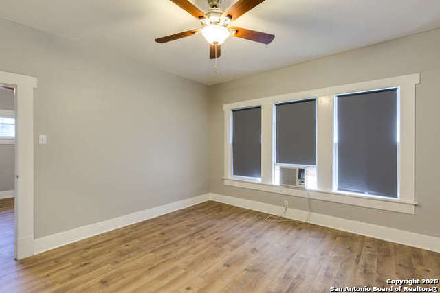 spare room with a ceiling fan, wood finished floors, and baseboards