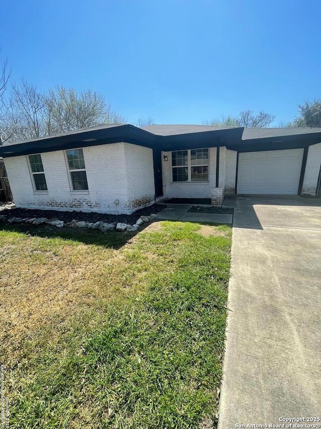 view of front of property featuring brick siding, an attached garage, driveway, and a front yard