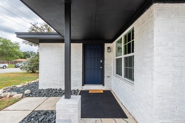 view of exterior entry with brick siding