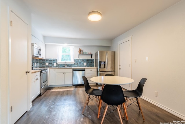 kitchen with a sink, decorative backsplash, dark wood-type flooring, and stainless steel appliances