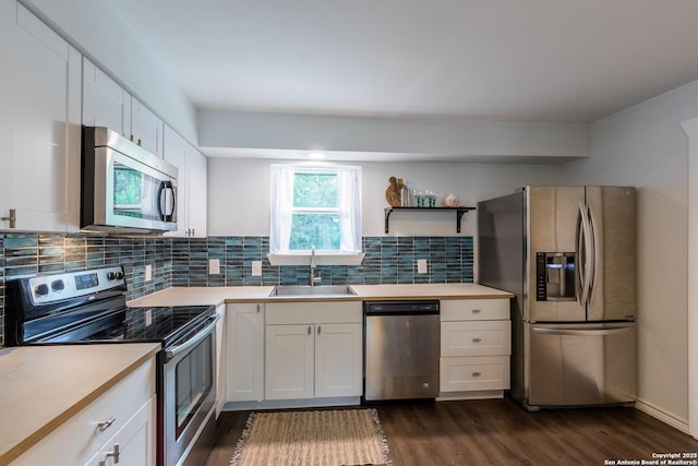 kitchen with decorative backsplash, light countertops, appliances with stainless steel finishes, and a sink