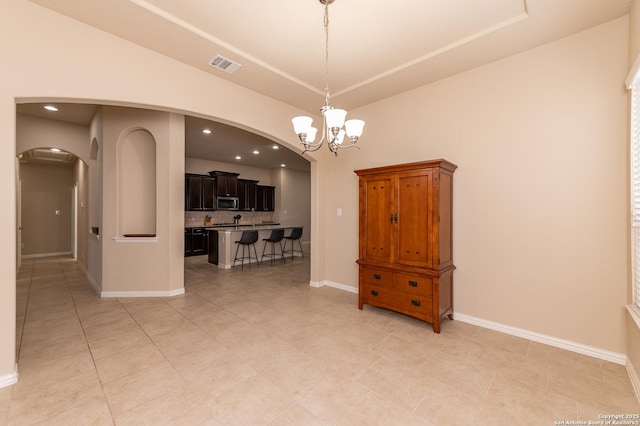 interior space with visible vents, baseboards, recessed lighting, arched walkways, and a notable chandelier