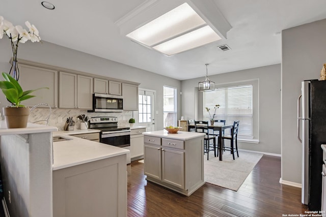 kitchen with decorative backsplash, dark wood-style flooring, visible vents, and appliances with stainless steel finishes