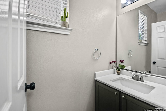 bathroom with vanity and a textured wall