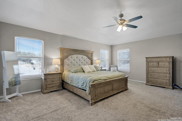 bedroom featuring baseboards, light colored carpet, and a ceiling fan