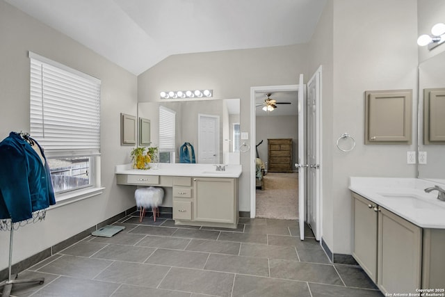 bathroom featuring a sink, ensuite bath, a ceiling fan, and vaulted ceiling