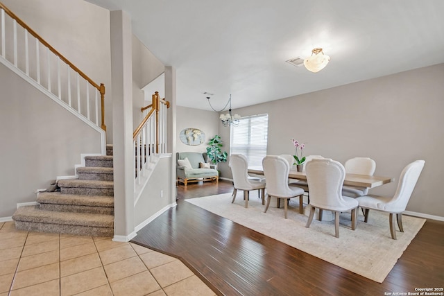 dining room featuring stairway, wood finished floors, visible vents, and a chandelier